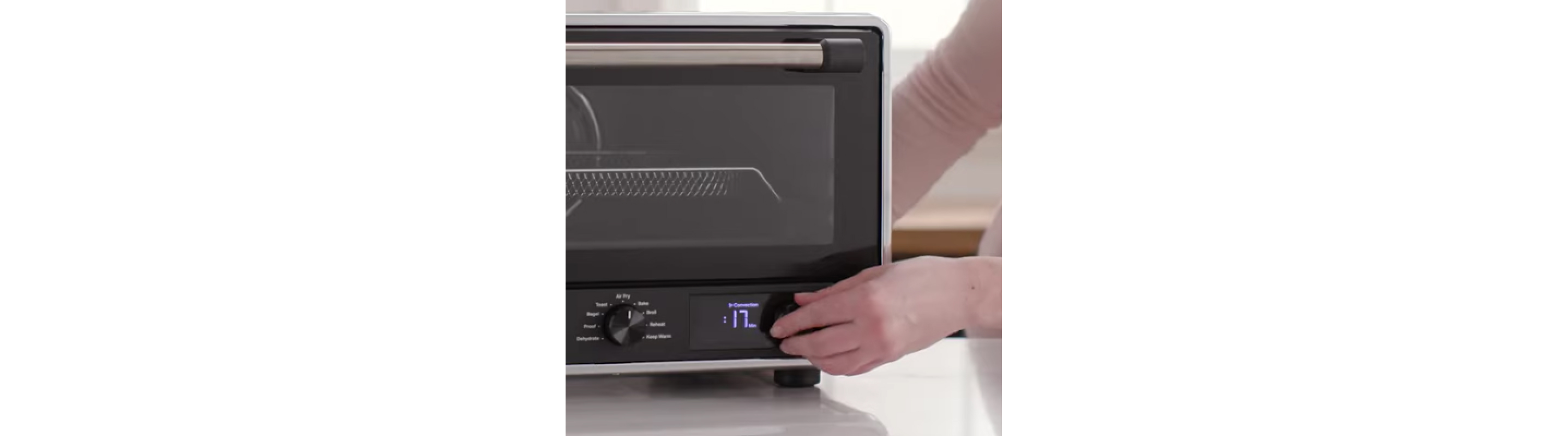 Close-up of person setting air fryer cooking time. 