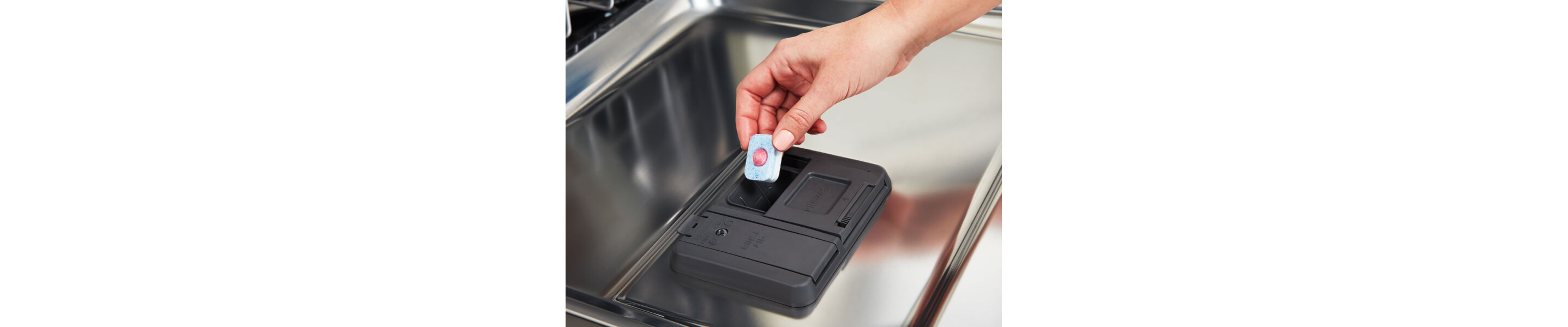 Person loading pod detergent into detergent compartment in dishwasher