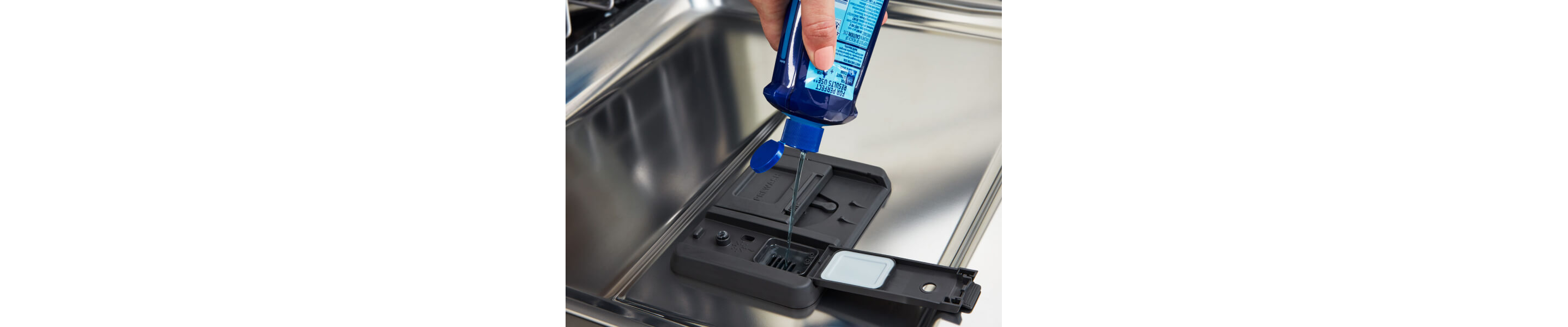 Close-up of person adding rinse aid to dishwasher rinse aid compartment