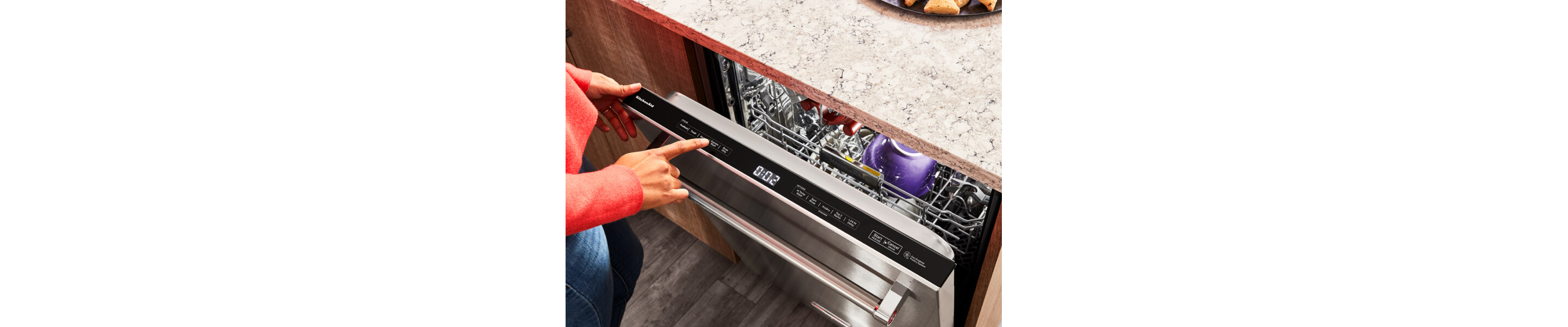 Person selecting settings on a top dishwasher control panel