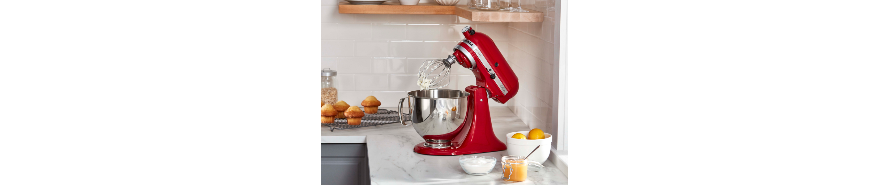 KitchenAid® stand mixer with a wire whip accessory with stiff egg white peaks in modern kitchen.