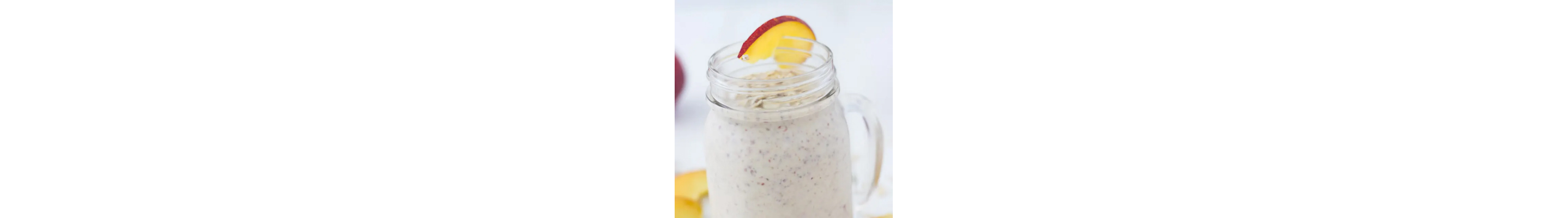 Smoothie in a mason jar with a peach on the rim
