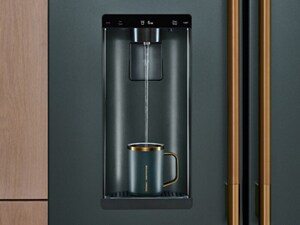 A mug getting filled with water from a KitchenAid® Refrigerator