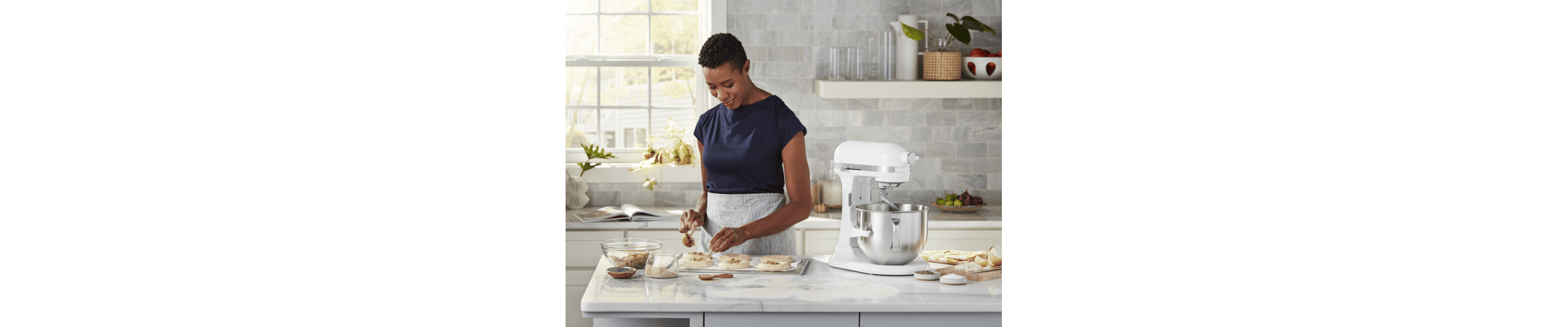 Woman baking at white marble countertop with white stand mixer 