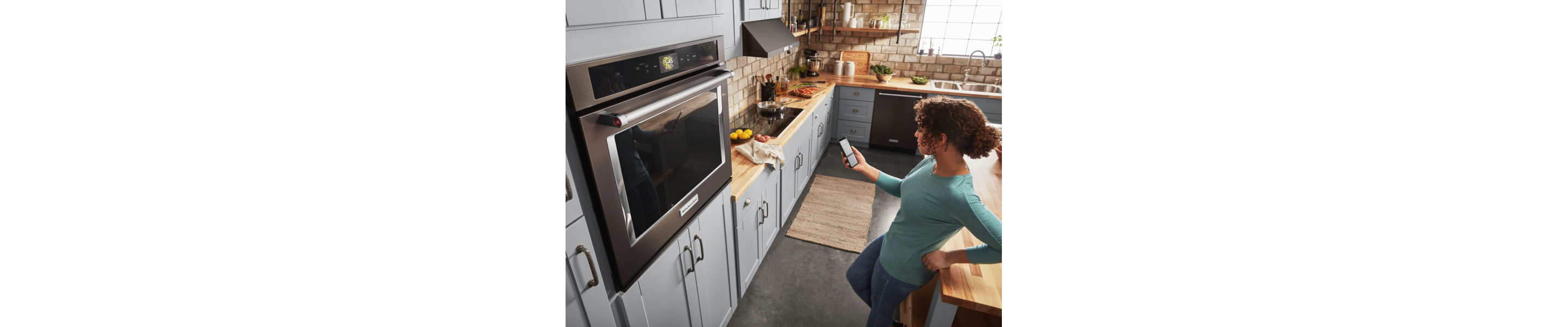 Person standing in front of a KitchenAid® wall oven