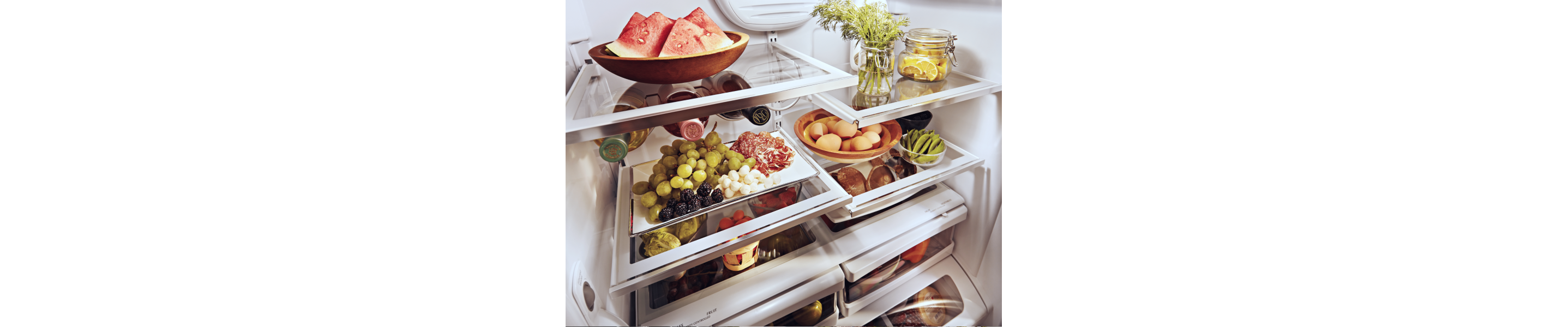  A stocked refrigerator with fresh fruit and ingredients.