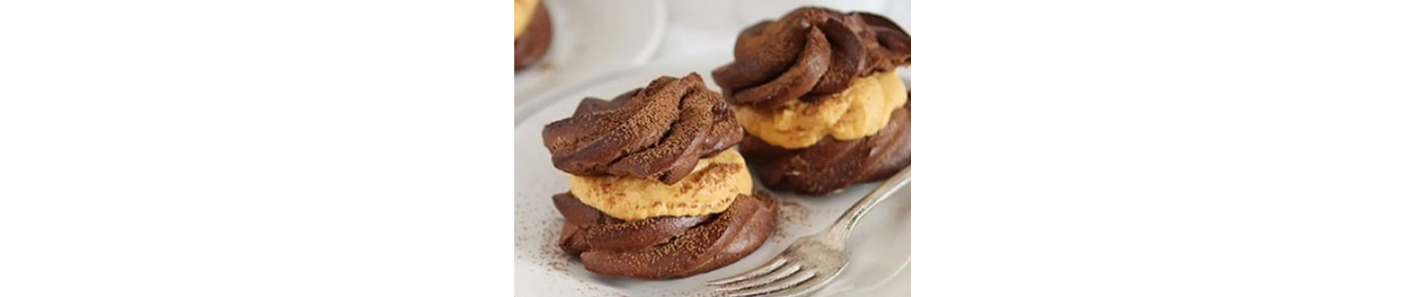 Pumpkin chocolate cream puffs next to fork