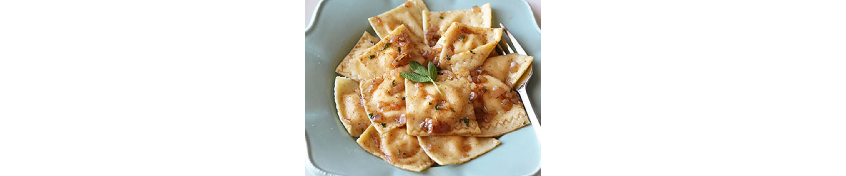 Pumpkin ravioli with browned butter sauce in a pale blue bowl