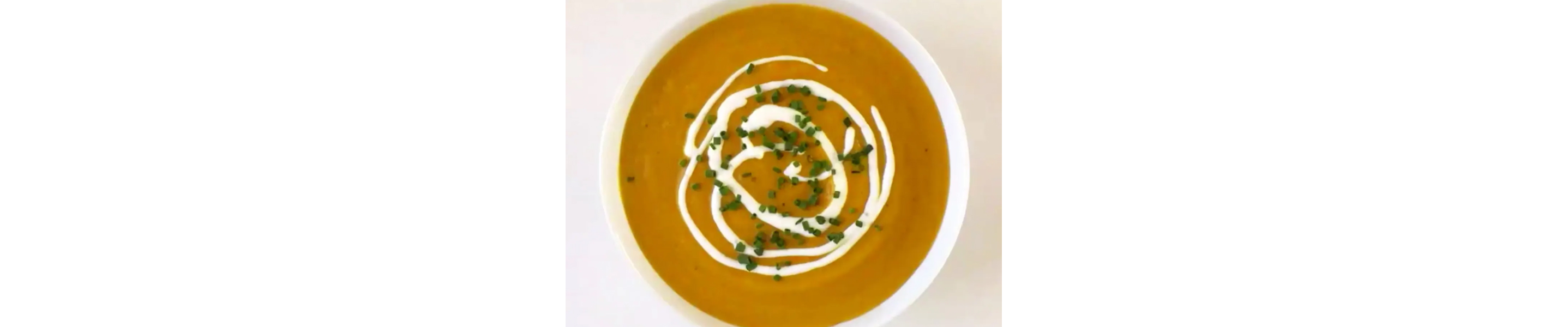 Creamy pumpkin soup garnished with green onions