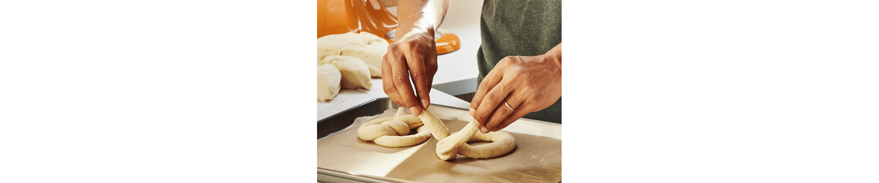 Person twisting dough into a pretzel shape 