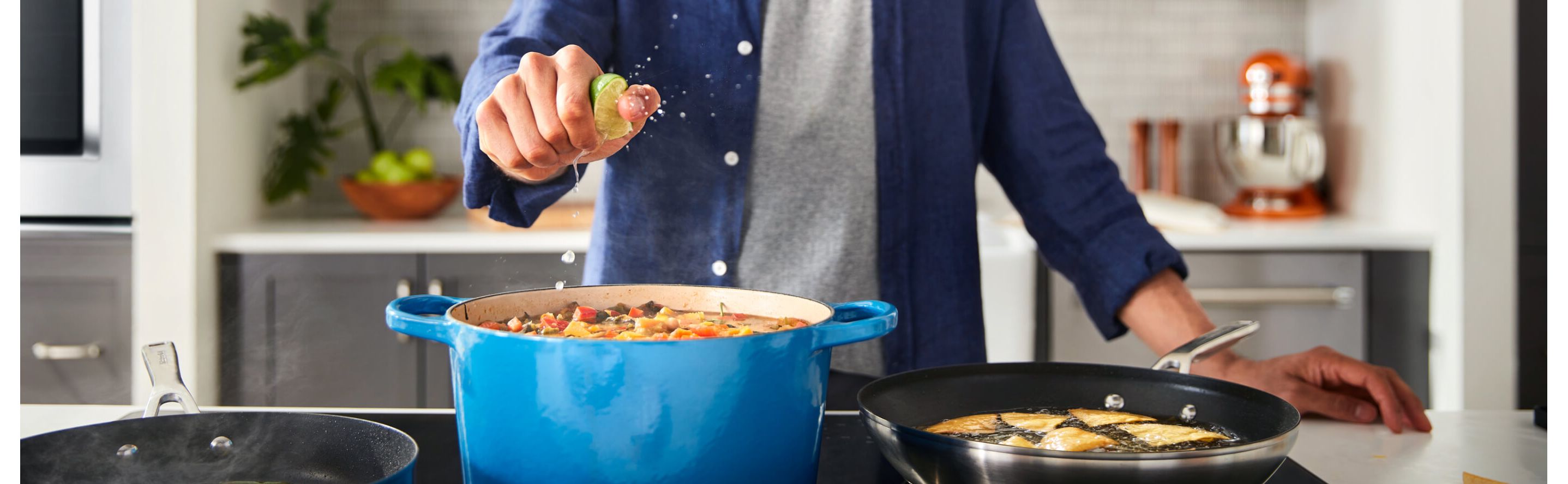Person squeezing lime into a stock pot over the stove