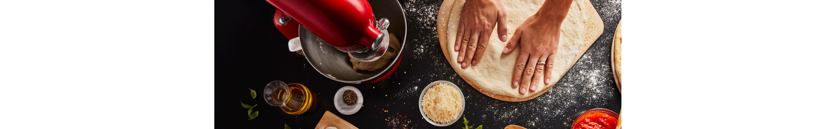 Person kneading stretching next to a KitchenAid® stand mixer