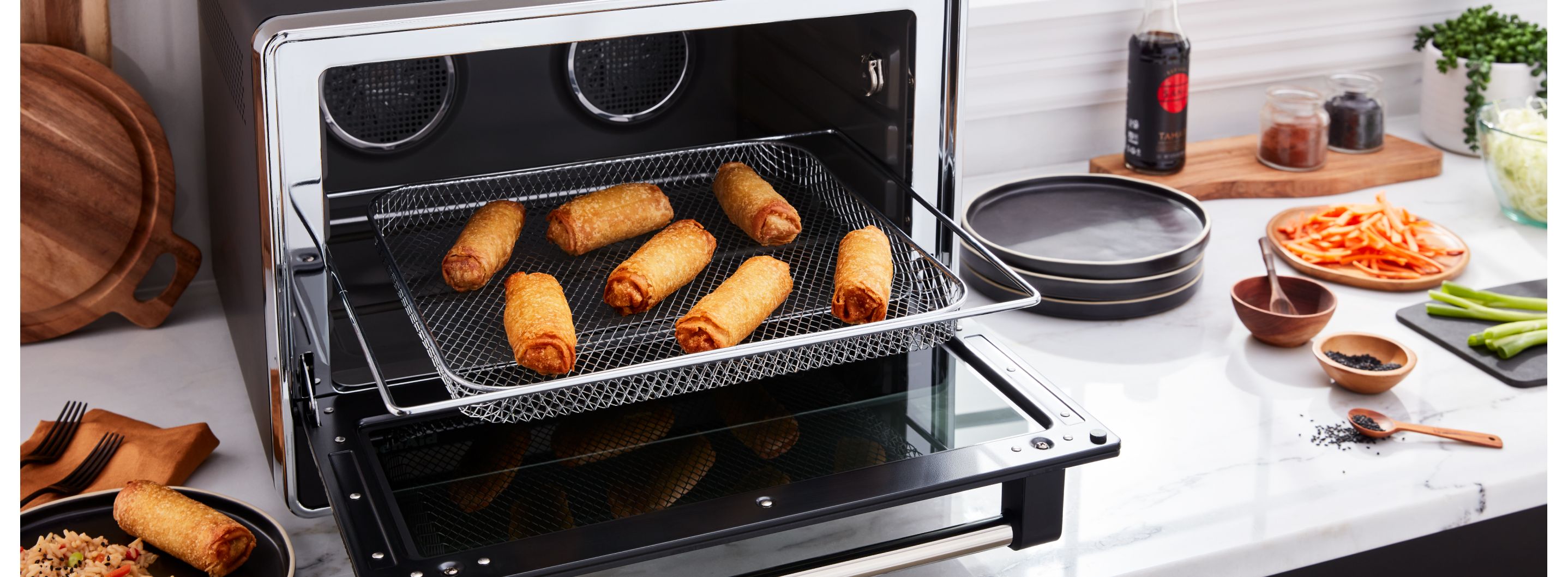Egg rolls being removed from a toaster oven