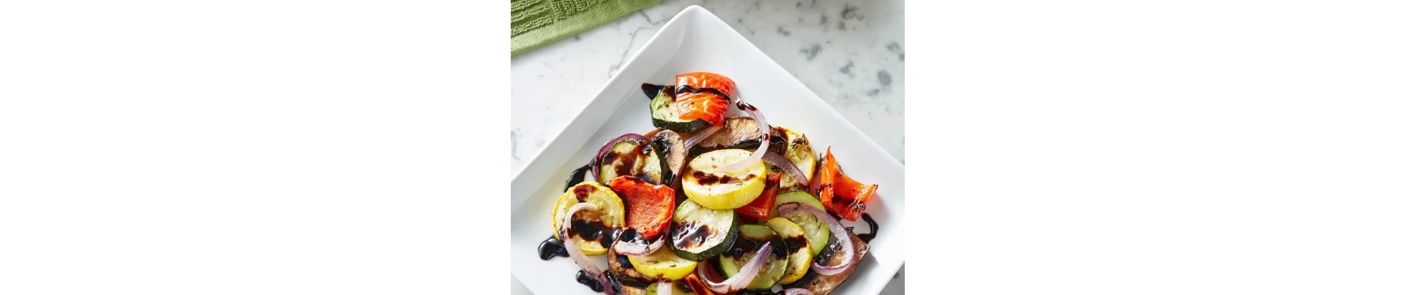 Assorted roasted vegetables drizzled in sauce