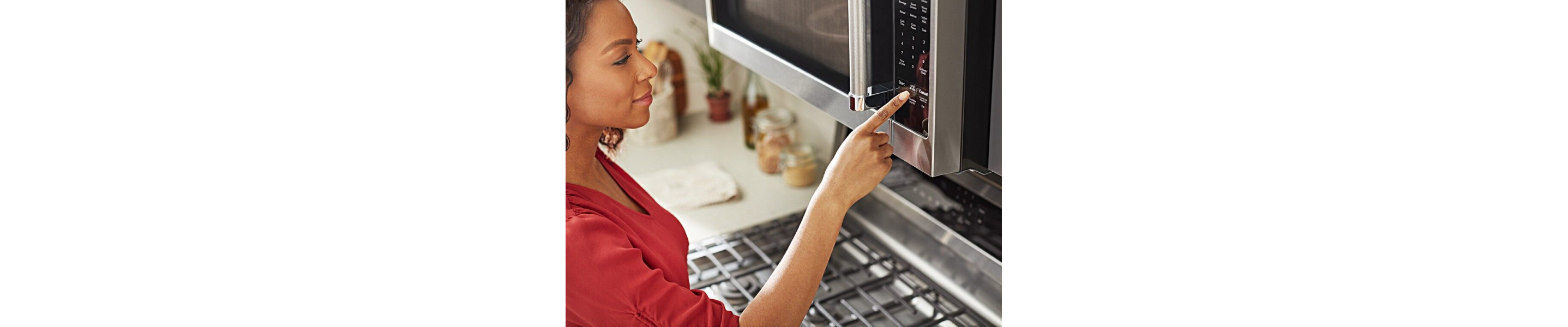 A Finger pressing a button on a microwave