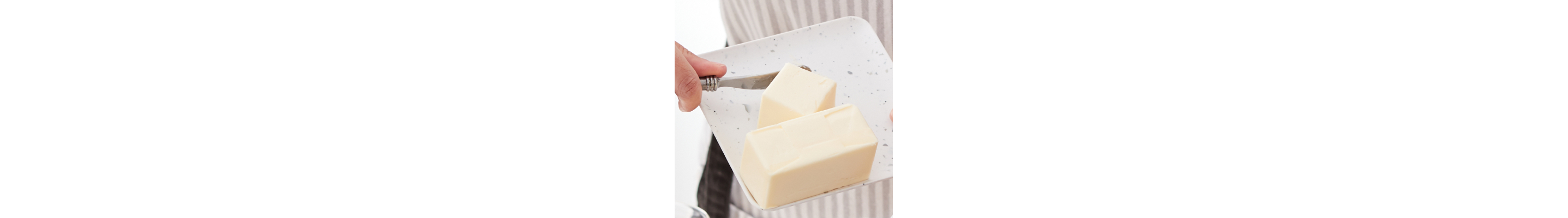 Person adjusting butter on a dish with a butter knife