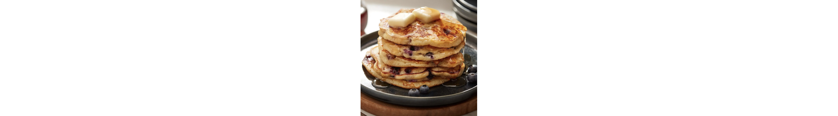 Plate of blueberry pancakes topped with syrup and butter
