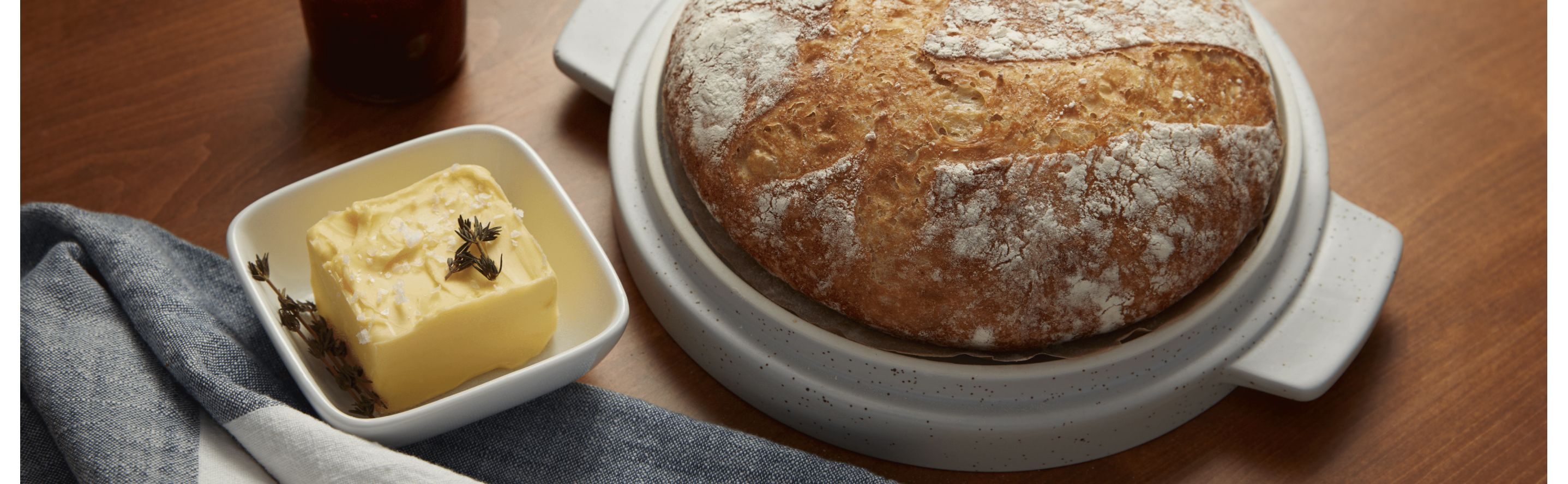 Loaf of sourdough bread next to dish of butter