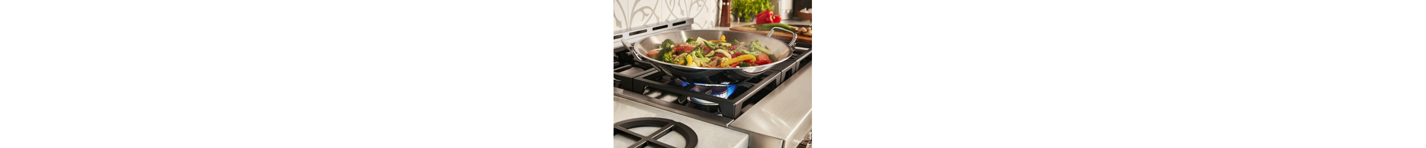 Large pan with vegetables cooking on power burner
