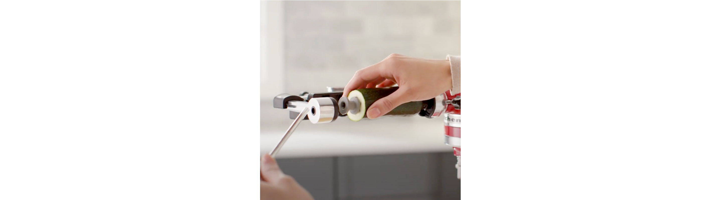 Zucchini being secured in a KitchenAid® Vegetable Sheet Cutter Attachment