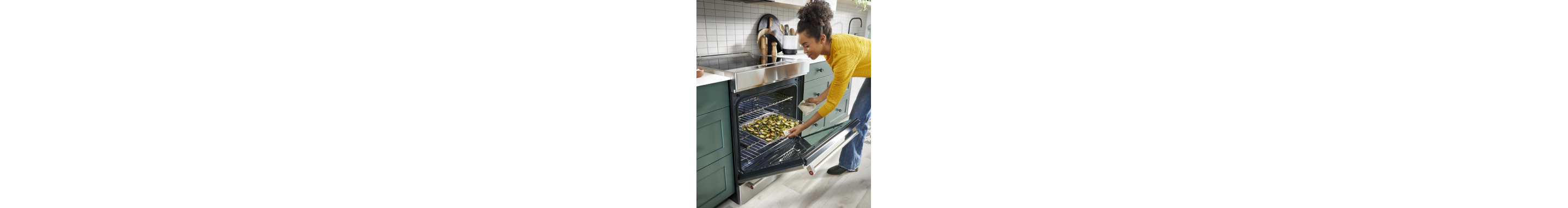 Person placing a baking sheet of vegetables into an electric range oven 