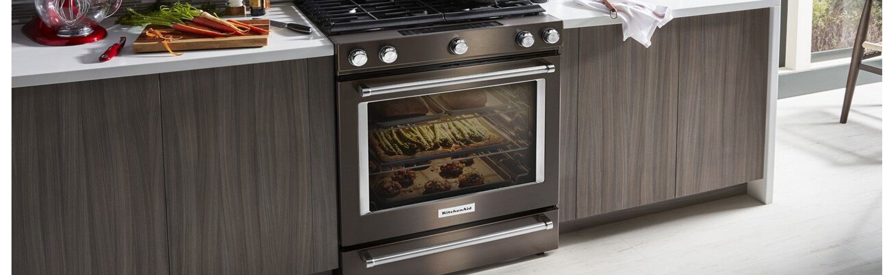 Black stainless steel KitchenAid® range next to dark cabinets