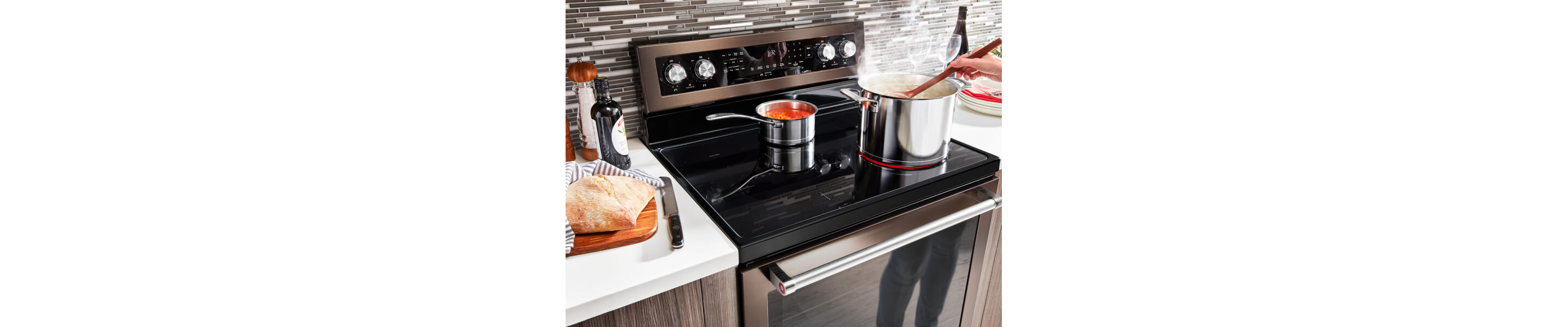 A pot and a sauce pan heating on an electric range