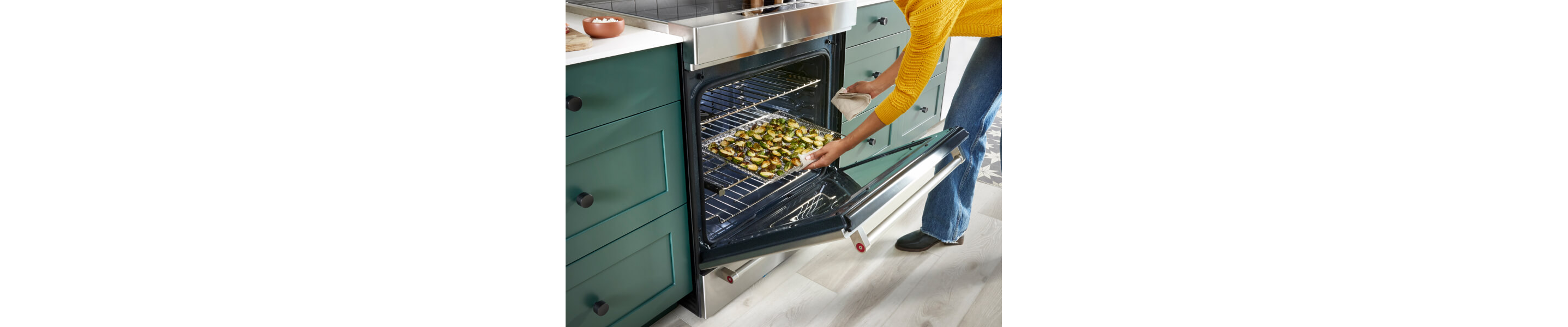A person pulling air-fried vegetables and potatoes out of a Air Fry Range
