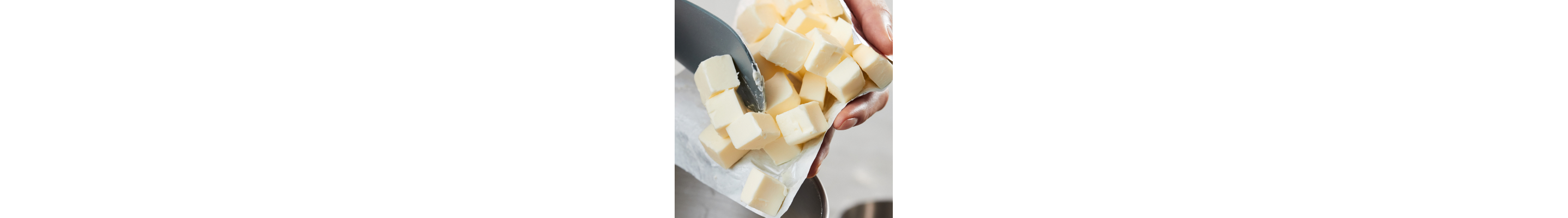 Person adding cubes of cold butter to stand mixer bowl
