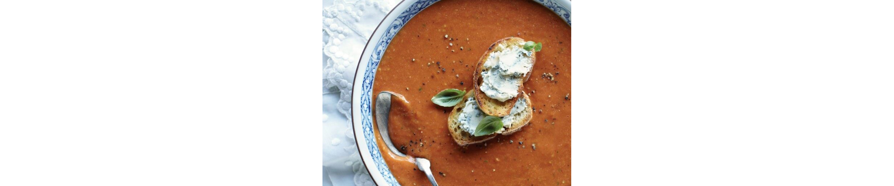 Birds-eye view of roasted tomato soup garnished with melba toast slices