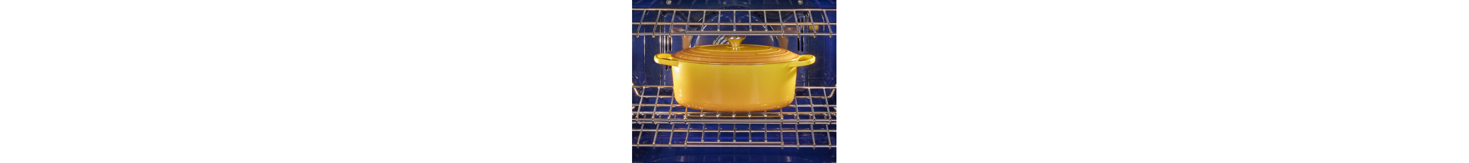 A yellow Dutch oven cooking inside of a KitchenAid® range
