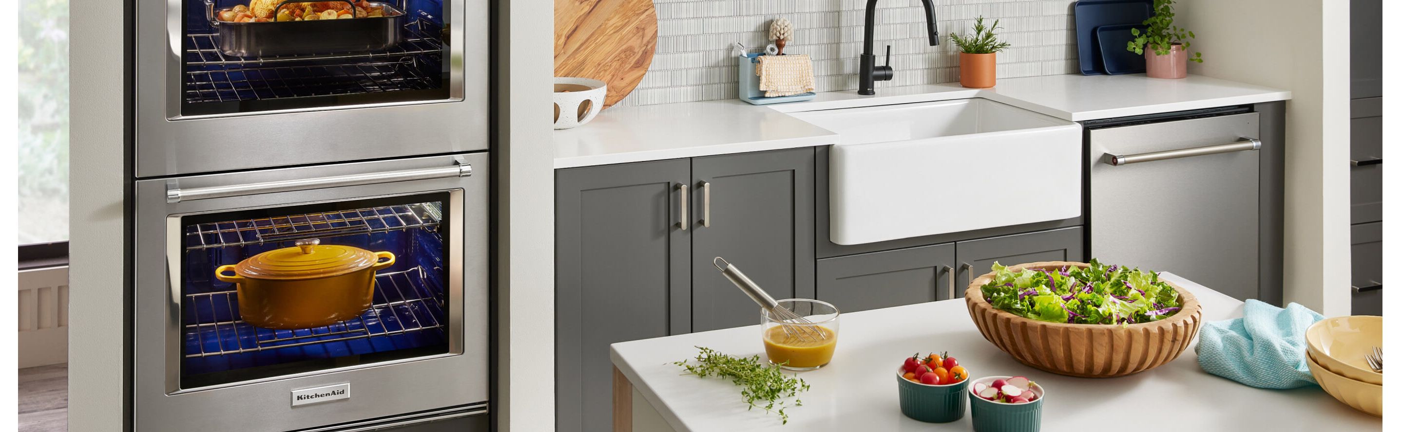 A modern kitchen with stainless steel KitchenAid® appliances and fresh food on the island