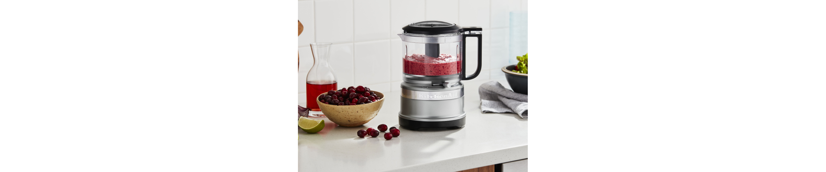 KitchenAid® food processor with pureed cherries and bowl of whole cherries