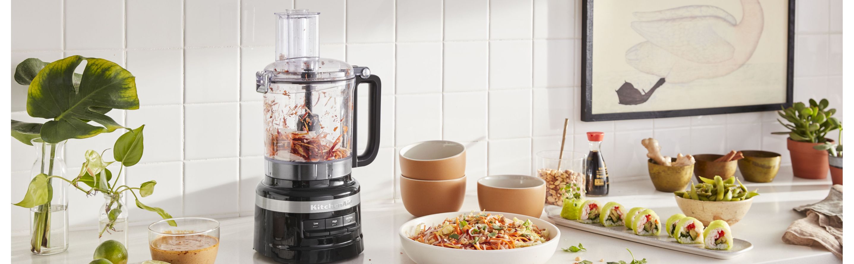 KitchenAid® food processor on countertop with sushi and cole slaw