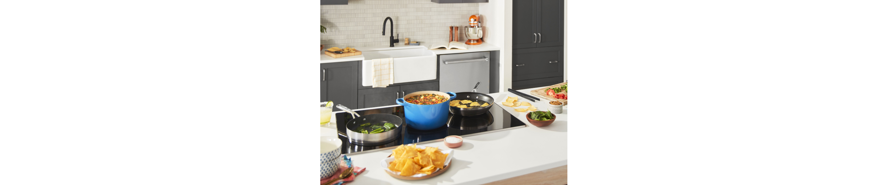 Cooktop with foods cooking in saute pans and dutch oven