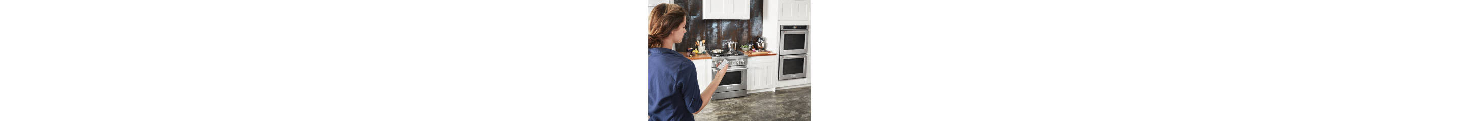 A person with a smartphone in a modern kitchen