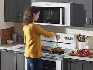A woman cooks at a white range