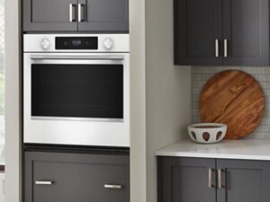 A kitchen with a white wall oven, counters and sink