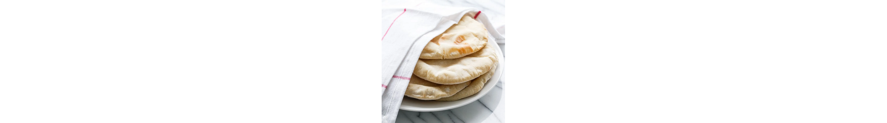 Pita bread on a plate covered with a cloth