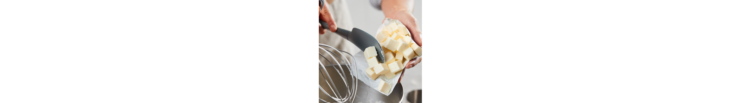 Person putting butter into a mixer bowl