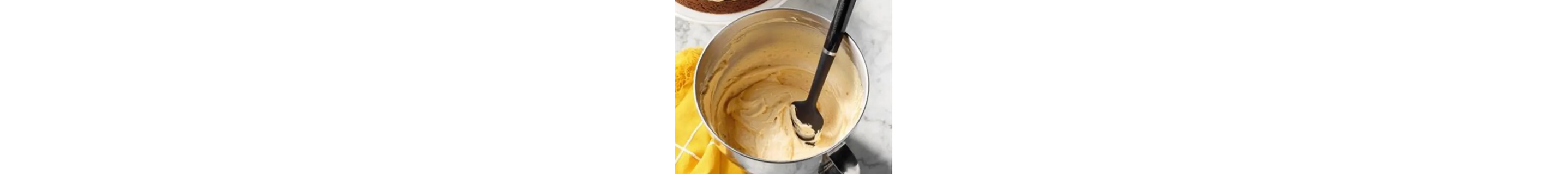 Whipped cream frosting and a spatula in a bowl