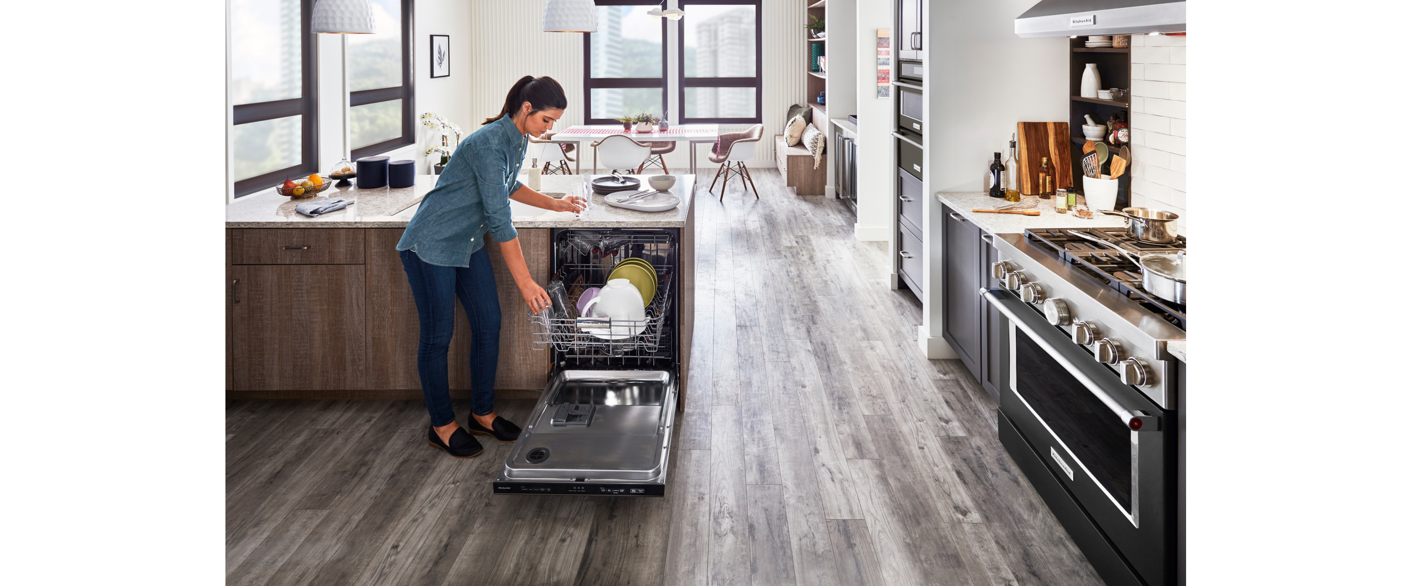 Person putting dishers in a KitcheAid® diswasher.
