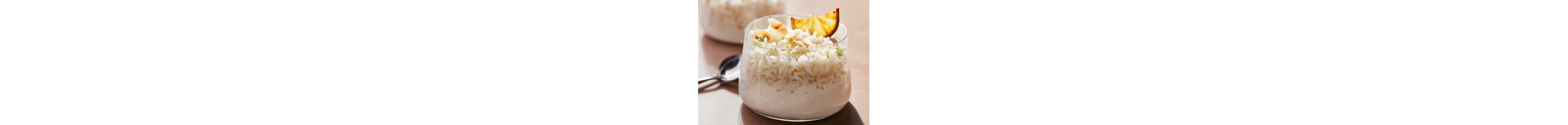 A bowl of rice pudding topped with cinnamon sticks and star anise.