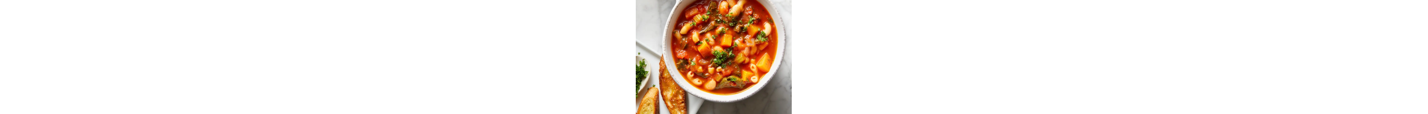 A bowl of white bean soup with a plate of toasted french bread beside it.
