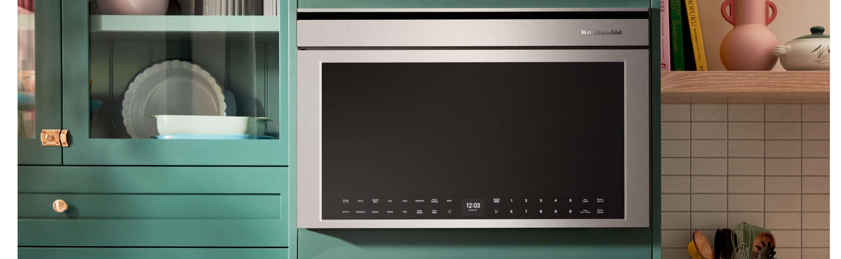Stainless steel KitchenAid® over-the-range microwave in bright blue cabinetry 