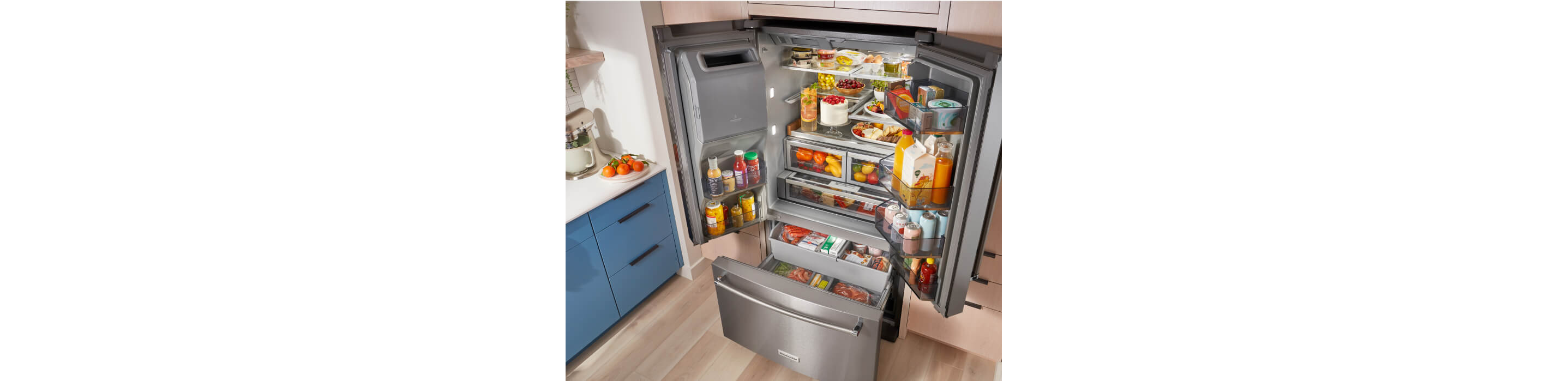 A fully loaded KitchenAid® French Door Bottom Mount Refrigerator with the doors and drawers open.