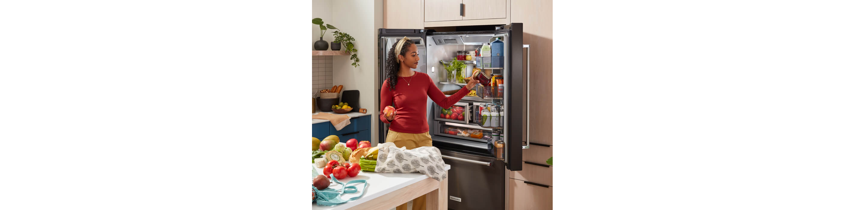 KitchenAid® French Door Bottom Mount Refrigerator actively being loaded.