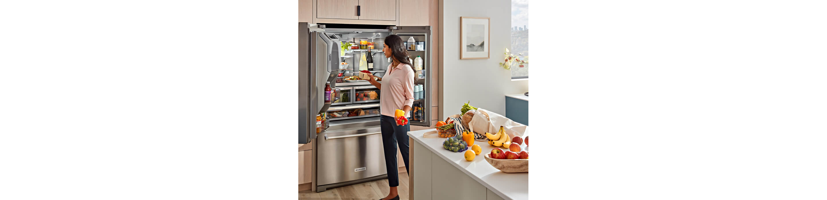 KitchenAid® French Door Bottom Mount Refrigerator actively being loaded.