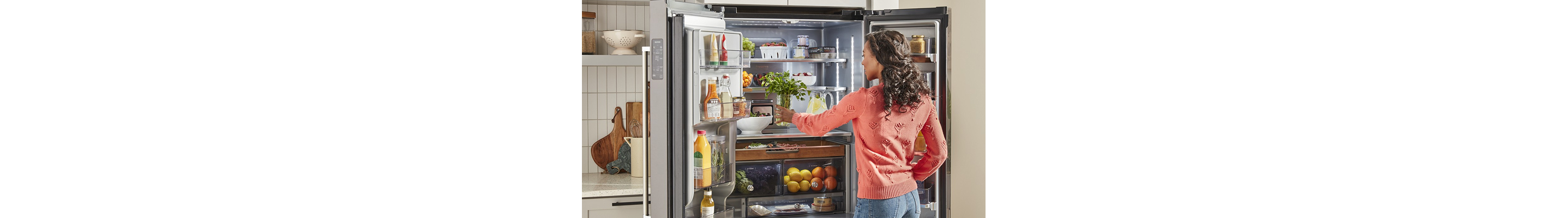Person placing herbs into KitchenAid® French Door Refrigerator