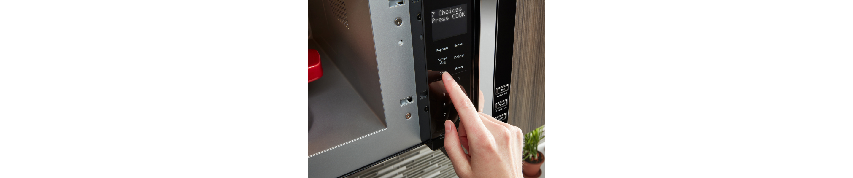 Person selecting a cooking setting on a microwave
